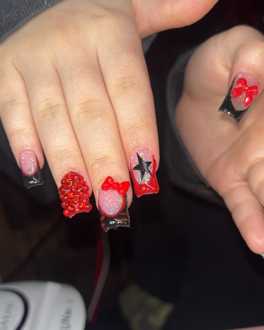 Red and black set with glitter, stars and a bow on the accent nail
